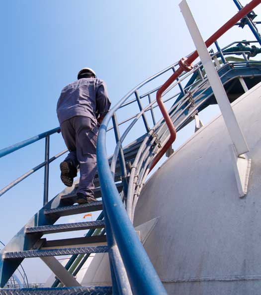 Person climbing manufacturing plant stairs